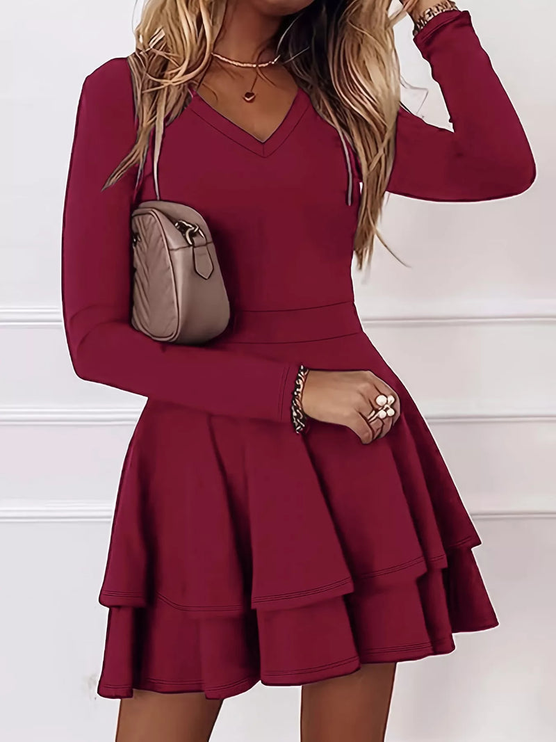 Red dress worn by a person with a beige handbag on a white background