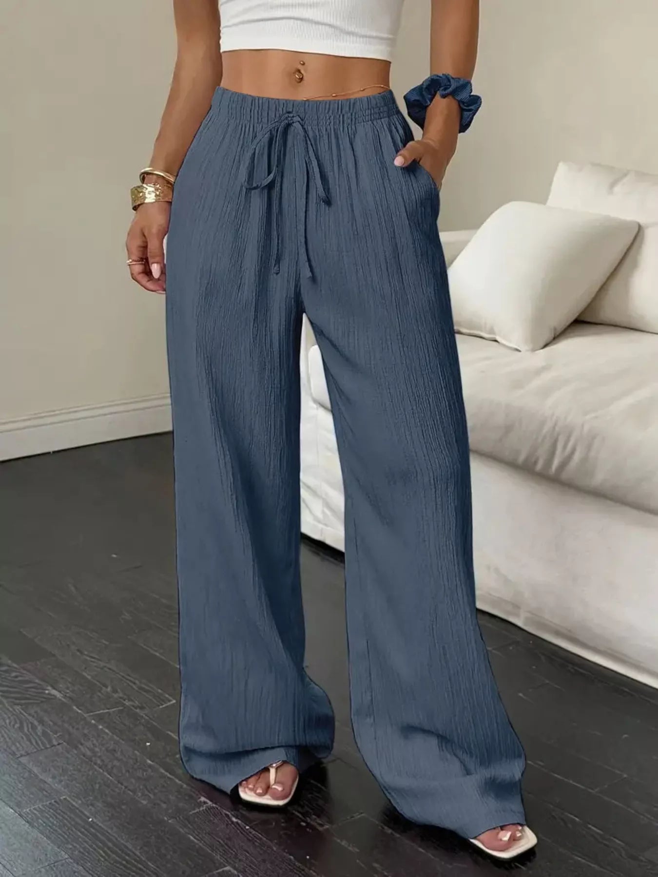 Person wearing blue wide-leg pants in a living room setting