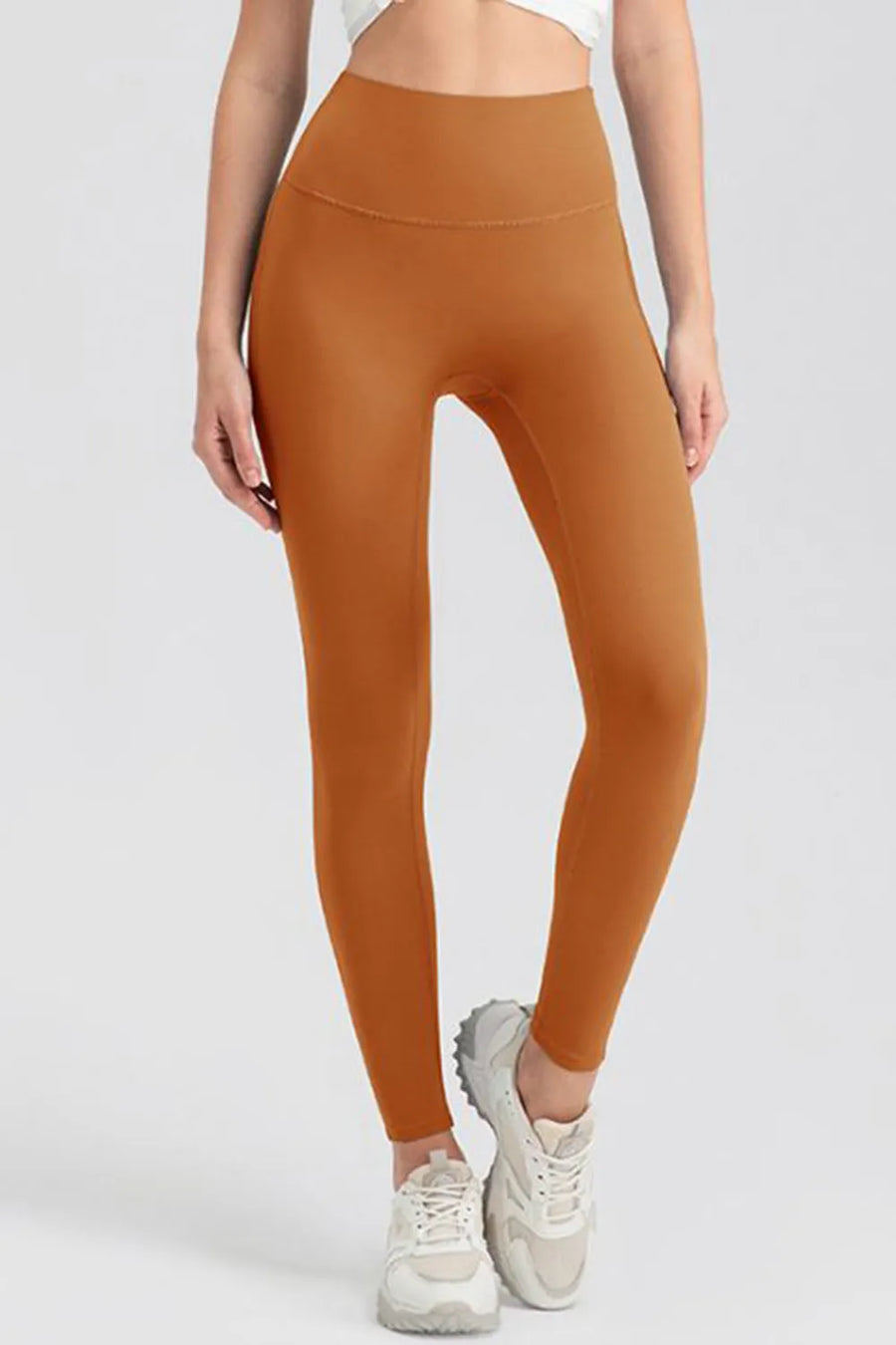 Person wearing orange leggings on a white background