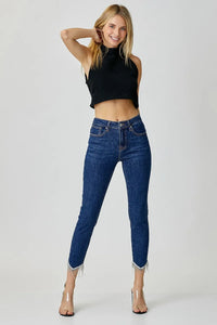 Woman wearing blue jeans and a black top on a white background