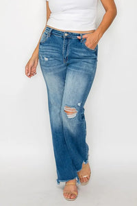 Person wearing blue jeans with slight distressing on a white background