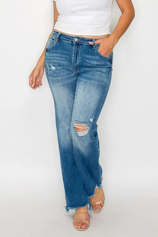 Person wearing blue jeans with slight distressing on a white background