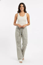 Woman wearing a white tank top and striped pants on a white background