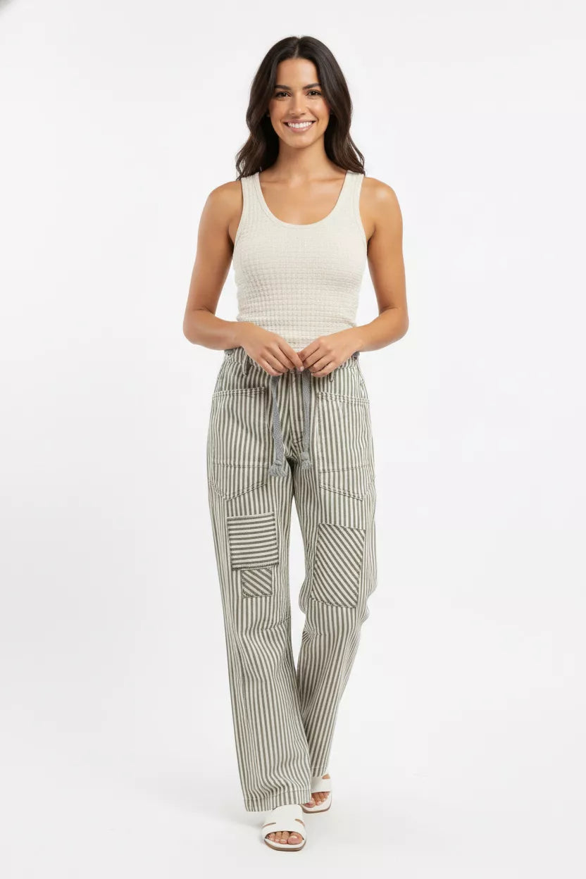 Woman wearing a white tank top and striped pants on a white background