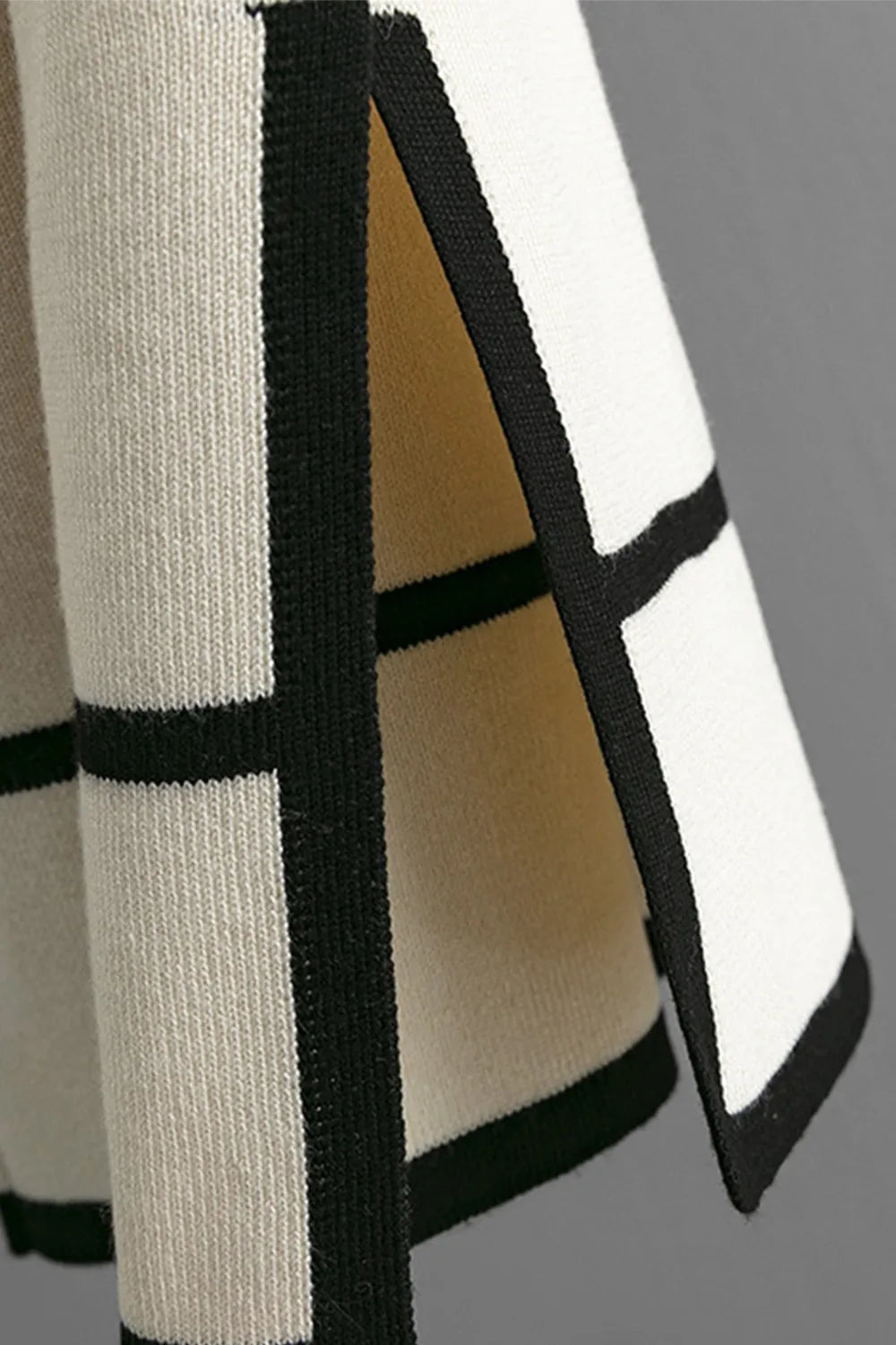 Close-up of a garment with black and white geometric pattern on a gray background