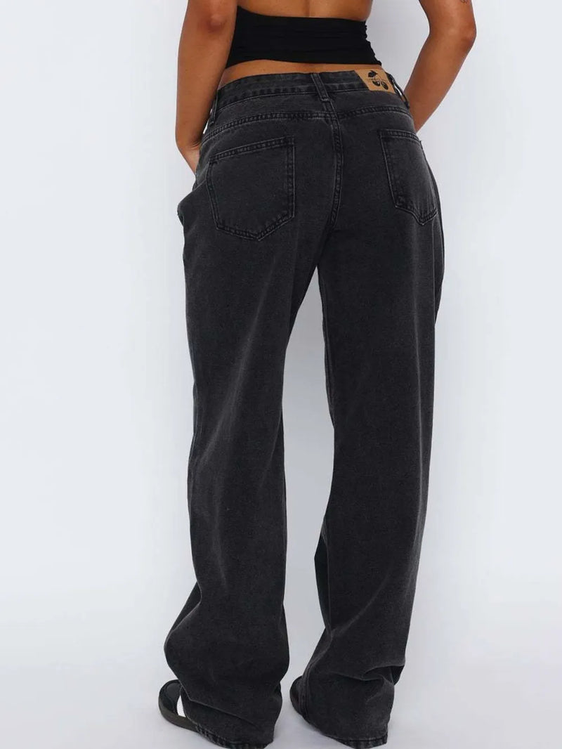 Person wearing black wide-leg jeans on a white background