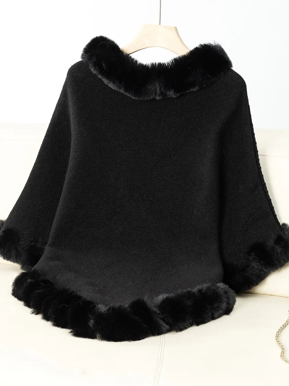 Black poncho with fur trim on a white background