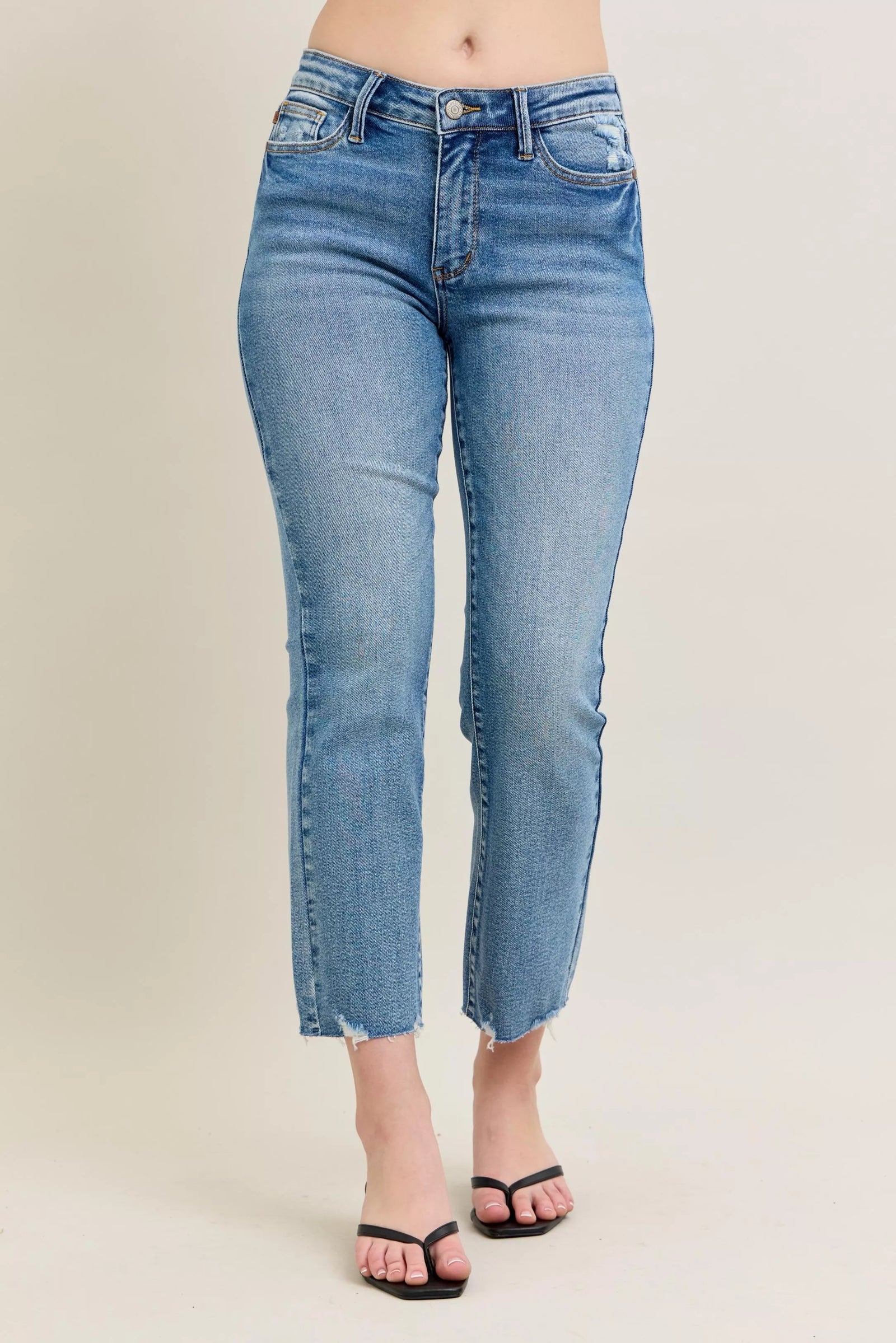 Blue jeans worn by a person on a beige background