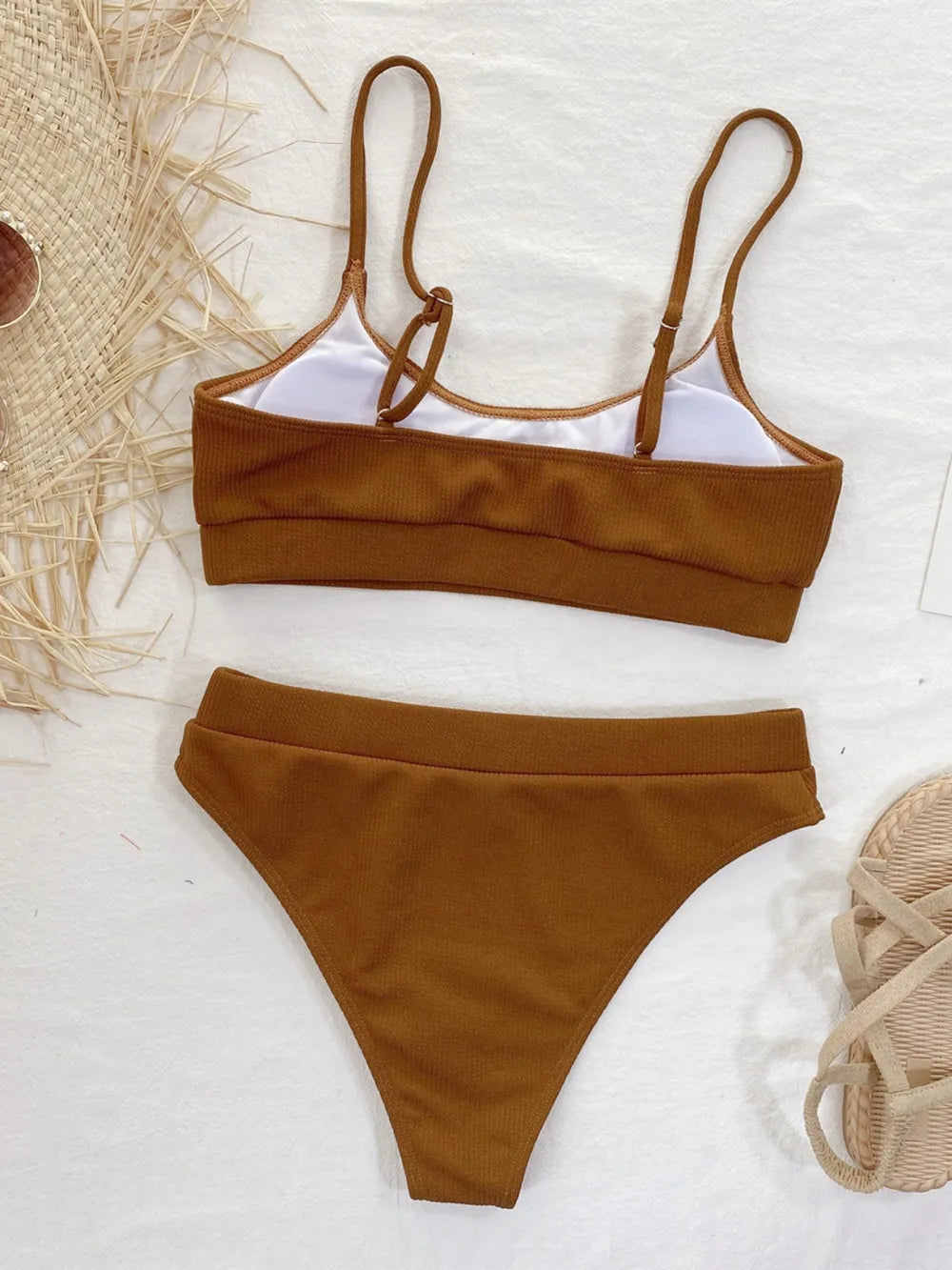 Brown bikini set on a light background with natural elements.