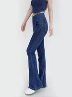 Person wearing blue flared jeans on a white background