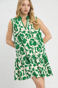 Woman wearing a green and white patterned dress on a plain background