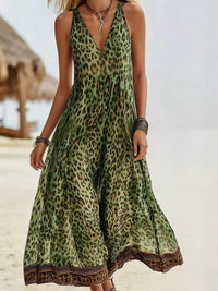 Woman wearing a green leopard print dress on a beach.