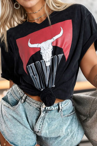 Person wearing a black t-shirt with a graphic design of a bull skull and the word 'VW'.
