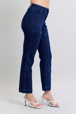 Dark blue jeans worn by a person on a light gray background