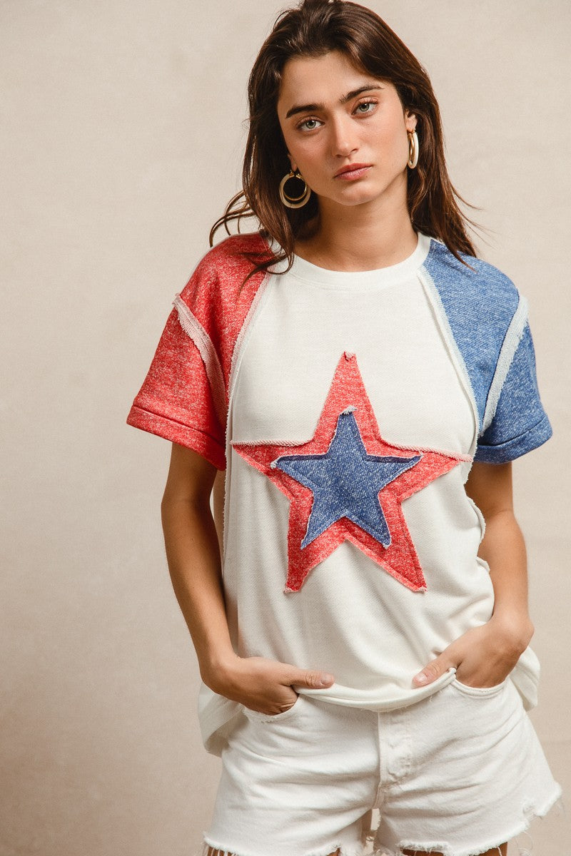 Woman wearing a white t-shirt with a red and blue star design on a beige background