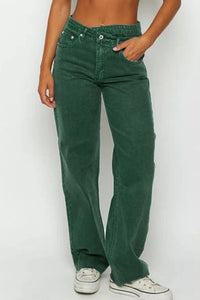 Green jeans worn by a person on a white background