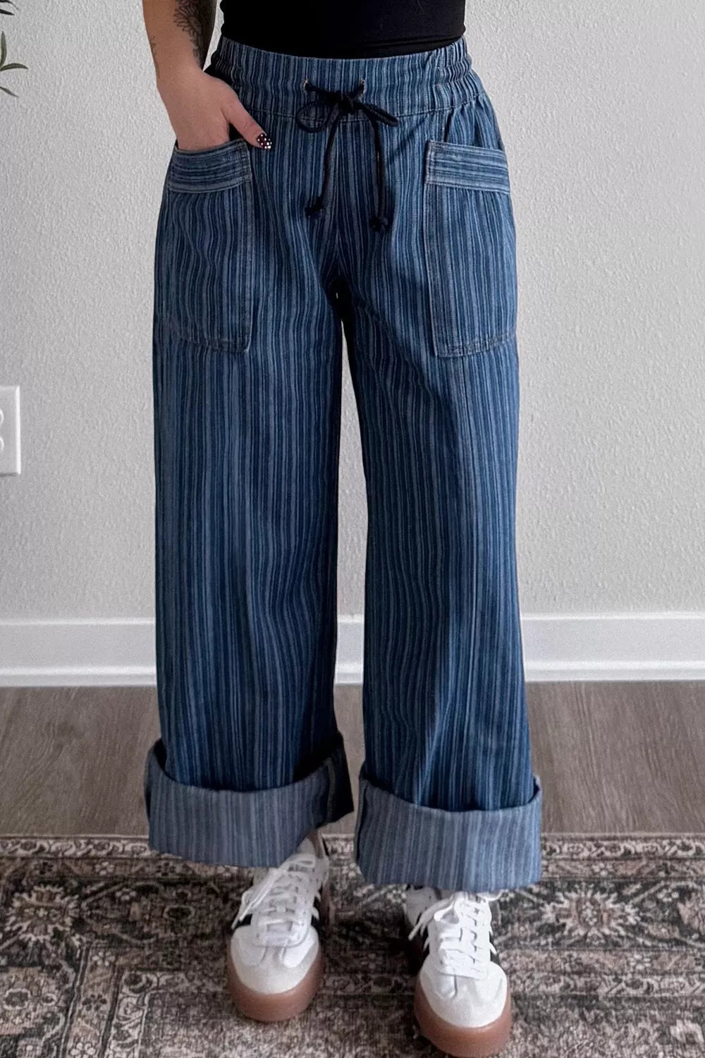 Person wearing blue striped pants with a plain background