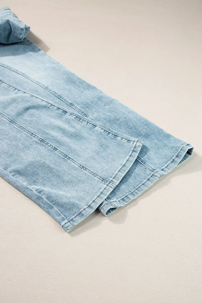 Rolled-up light blue denim jeans on a beige background