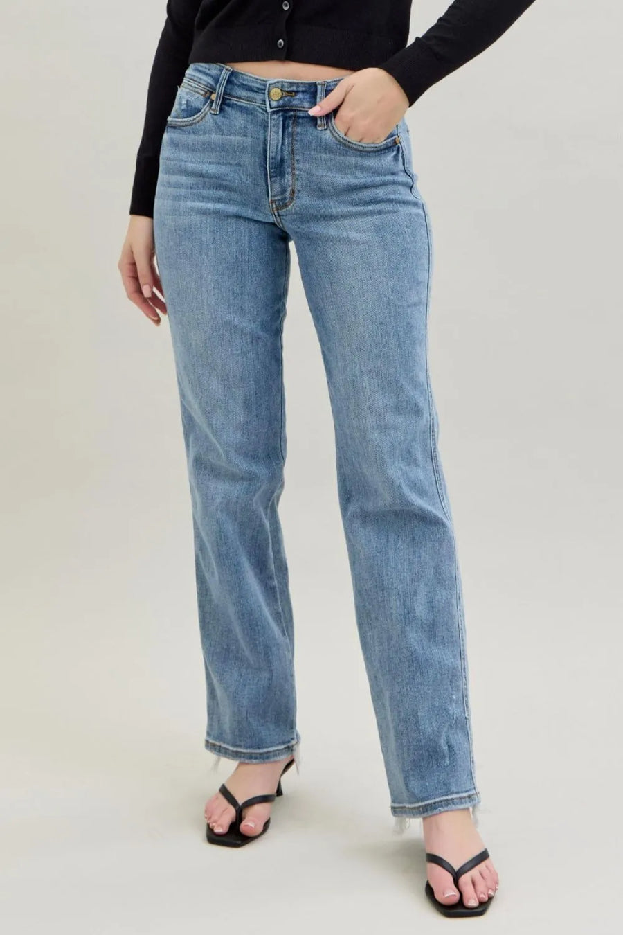 Person wearing light blue jeans on a plain background