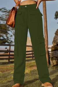 Person wearing green pants with a brown leather bag in an outdoor setting.