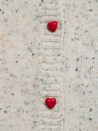 Two red heart-shaped objects on a textured beige fabric background