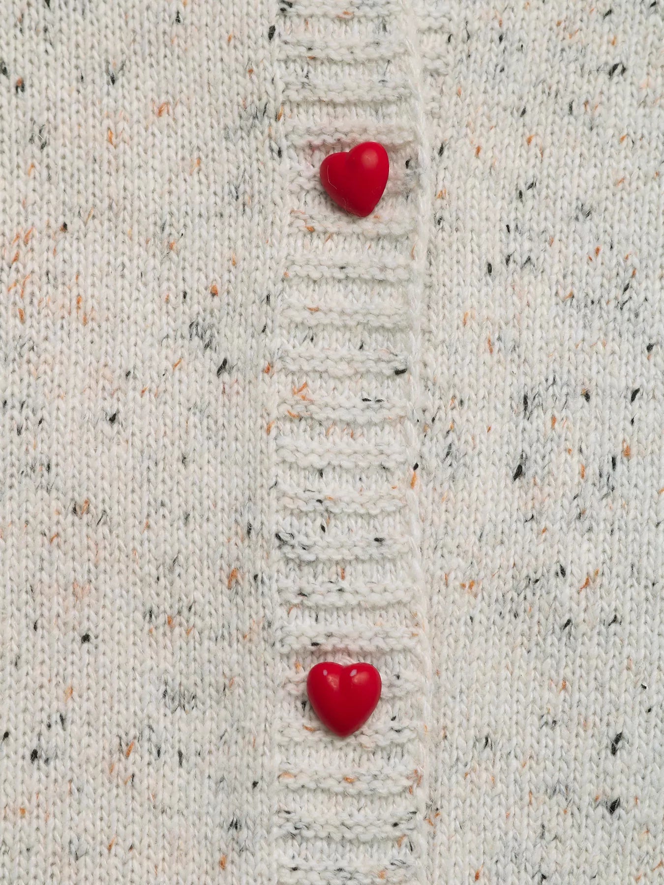 Two red heart-shaped objects on a textured beige fabric background