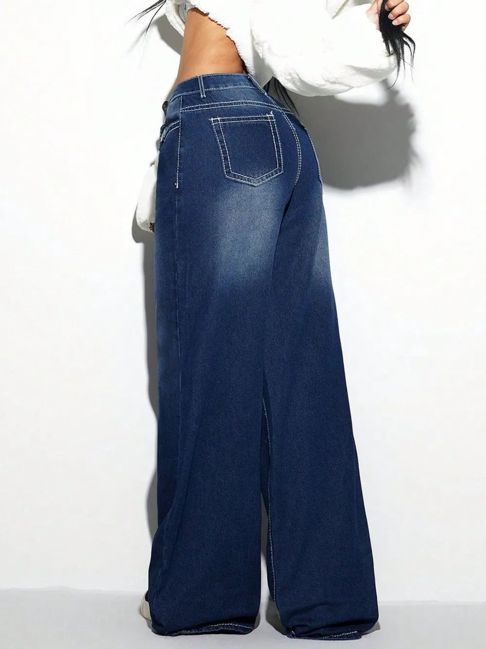 Blue wide-leg jeans worn by a person on a white background