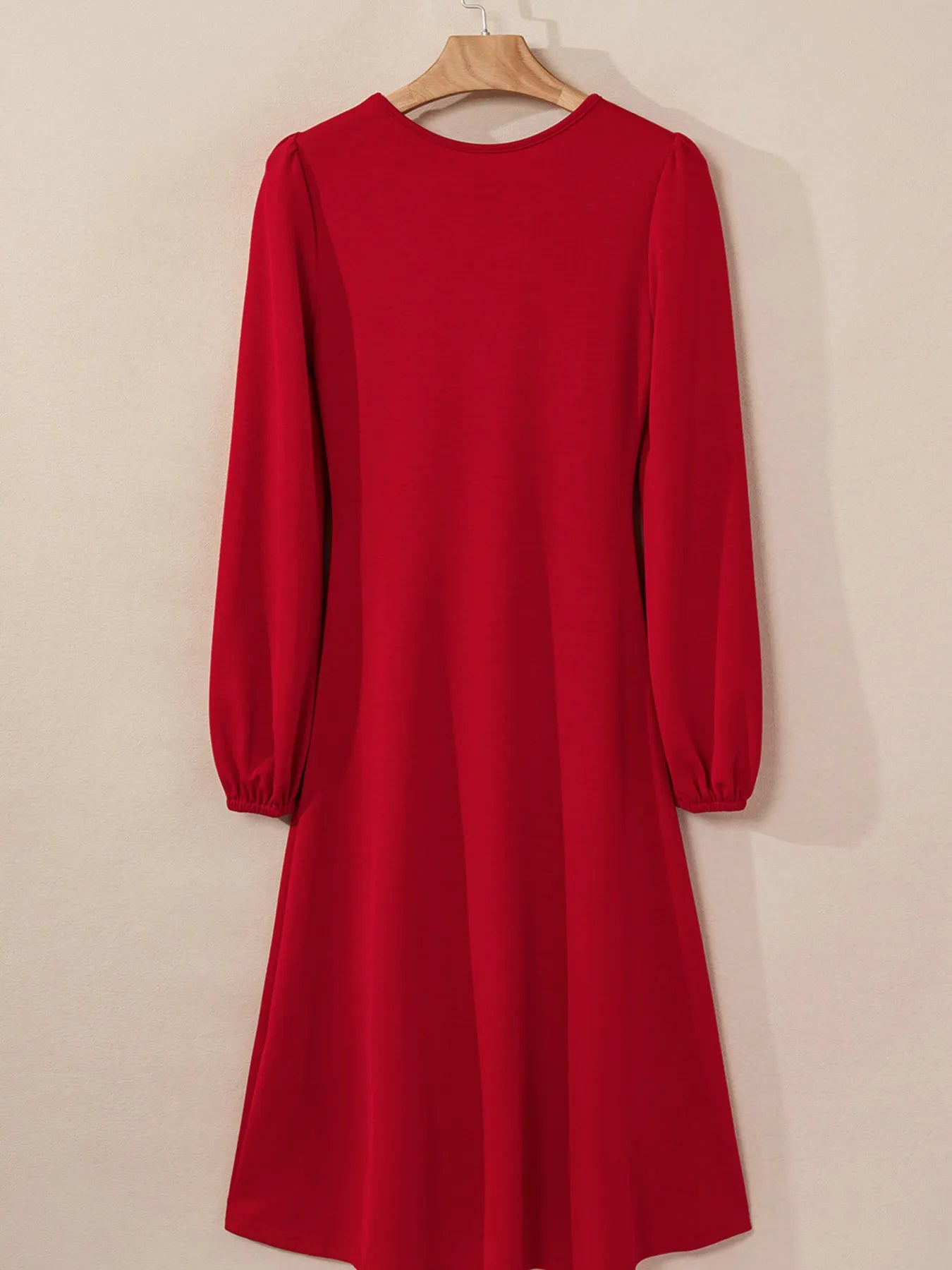 Red dress with long sleeves on a beige background