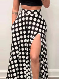 Black and white polka dot skirt with a high slit on a plain background