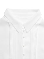 Close-up of a white shirt with a collar and buttons on a light gray background