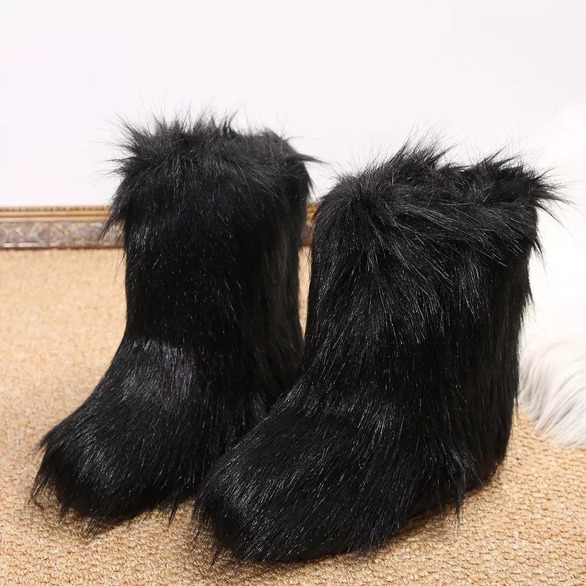 Pair of black furry slippers on a carpeted floor.