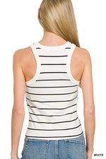Woman wearing a white tank top with black stripes and blue jeans on a white background