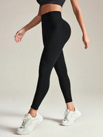Person wearing black leggings and white sneakers on a plain background