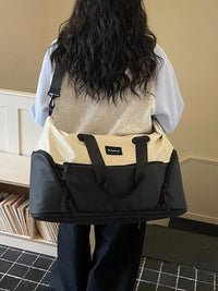 Person carrying a black and beige bag in an indoor setting