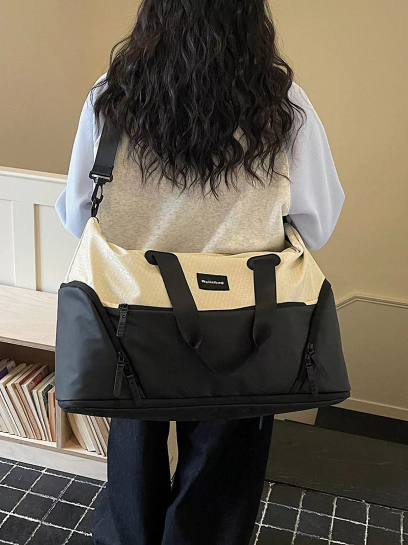 Person carrying a black and beige bag in an indoor setting