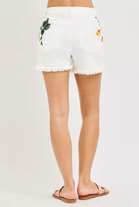 White shorts with floral embroidery on a plain background