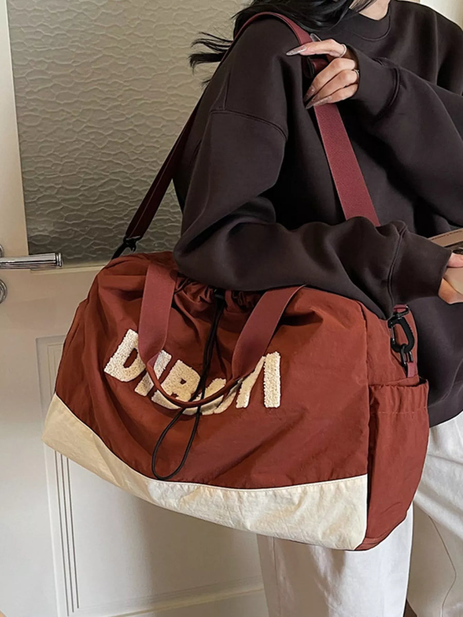 Person holding a brown and beige bag with 'Dior' branding.