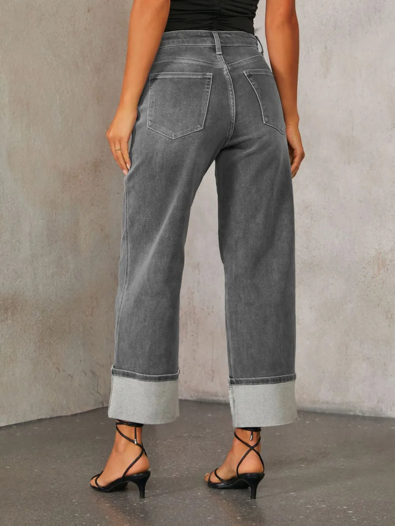 Person wearing gray wide-leg jeans against a plain background