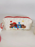 Quilted pouch with a embroidered dog design on a white surface