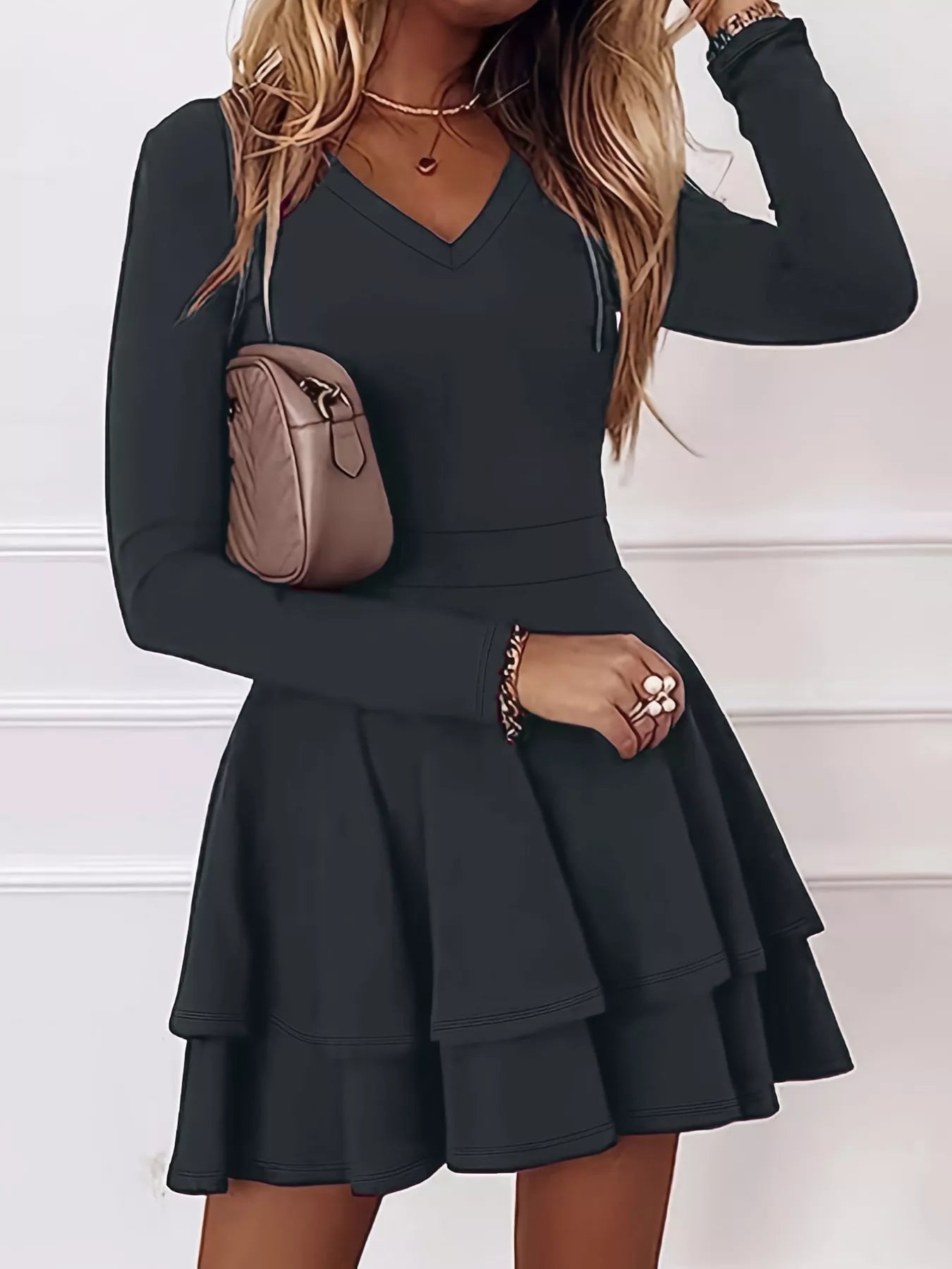 Black long-sleeve dress worn by a person with a neutral background