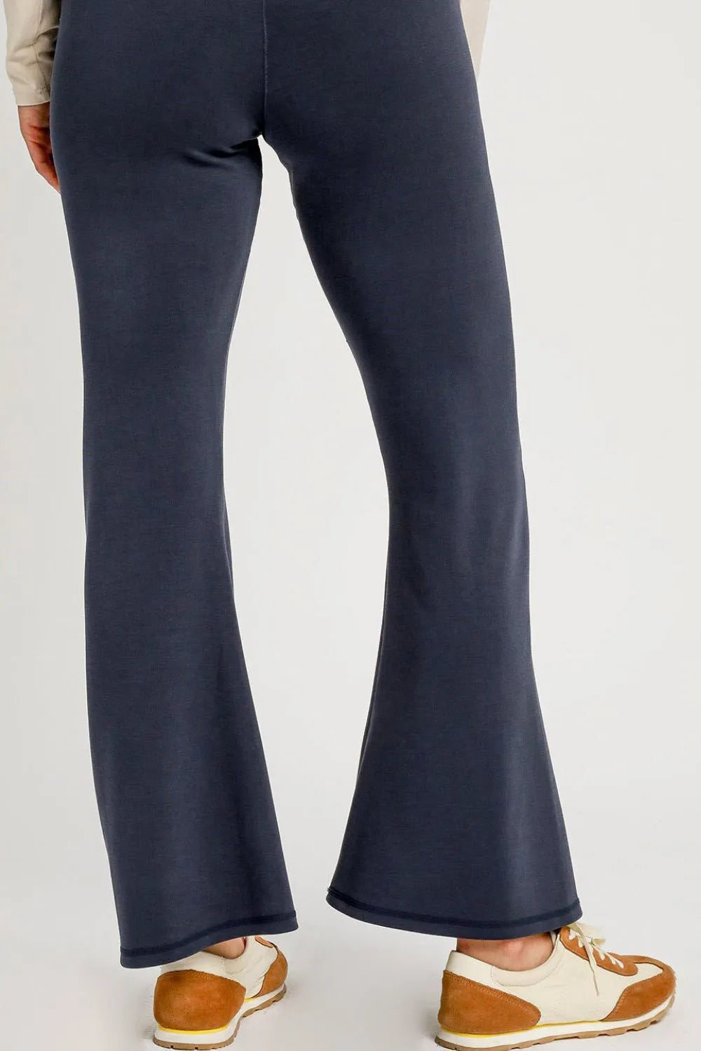 Navy blue flared pants worn by a person on a white background