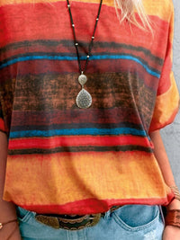 Person wearing a colorful striped shirt with a pendant necklace.