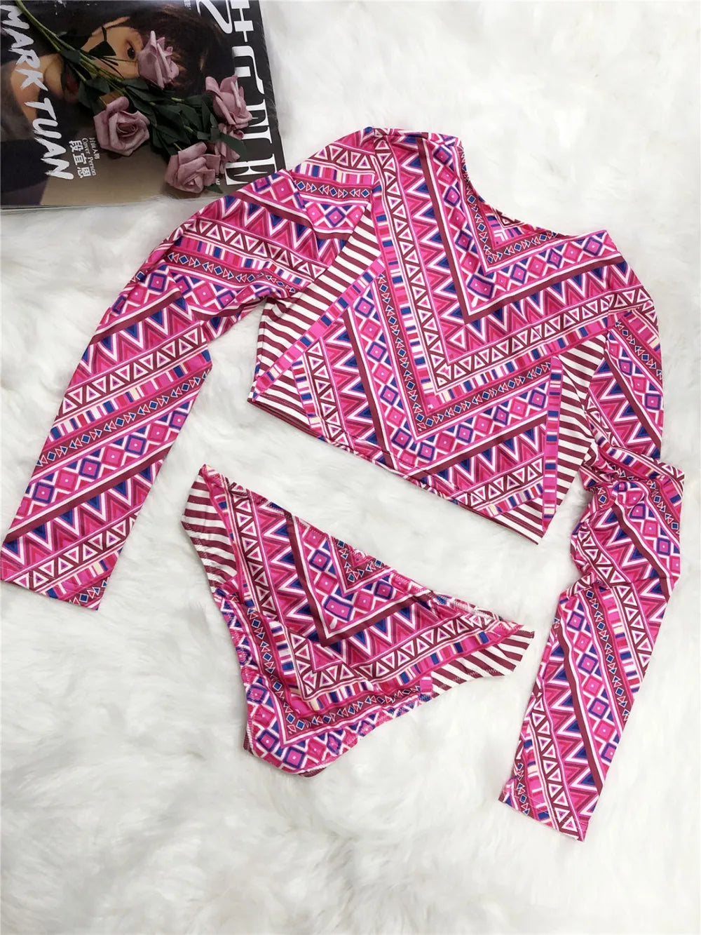 Pink and purple patterned top with matching scarf on a white surface