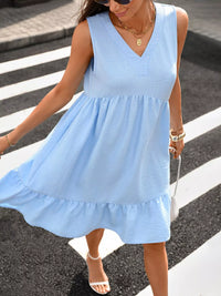 Woman wearing a light blue dress crossing a street.