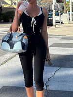 Person in black outfit holding a blue handbag on a city street