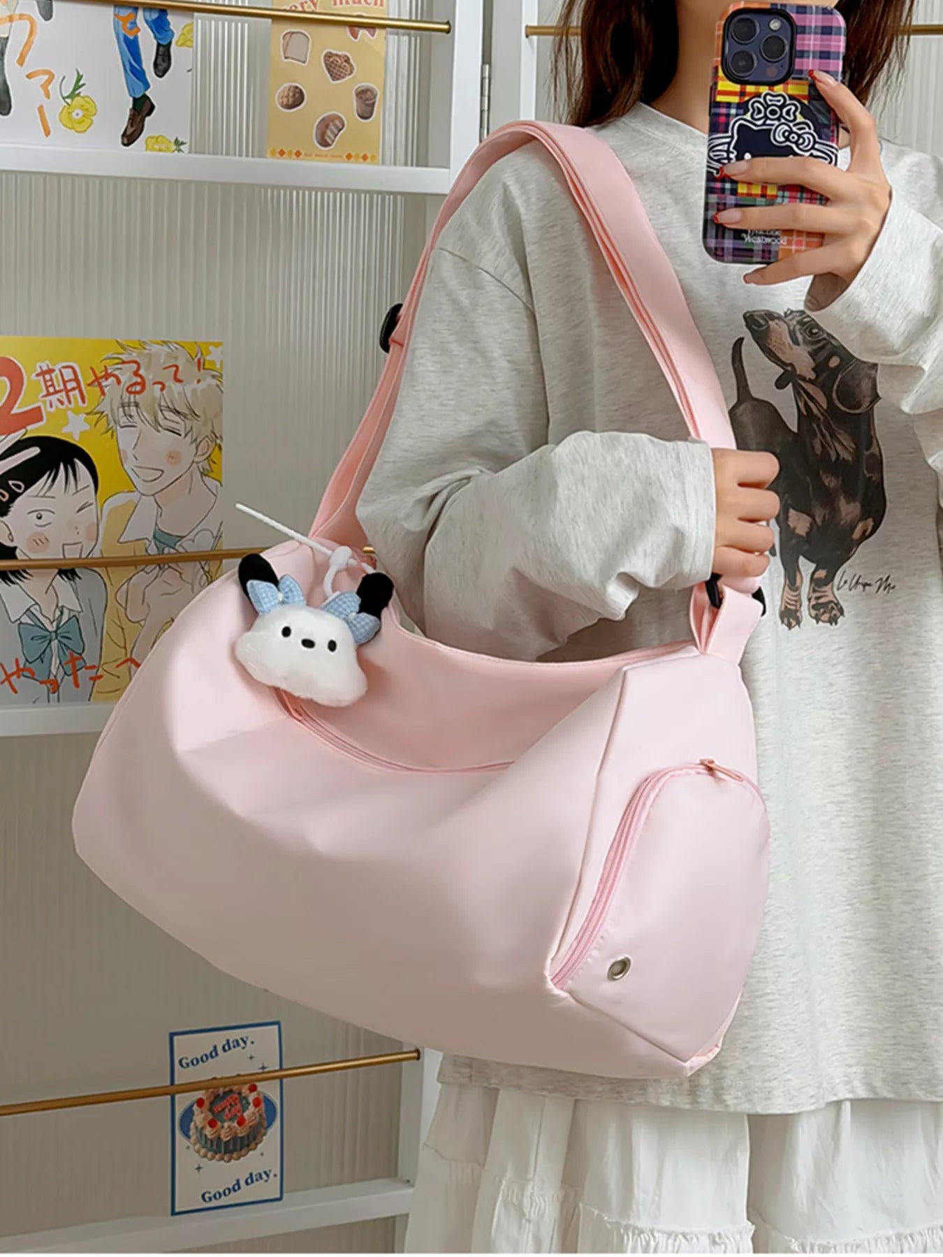 Person holding a pink bag with a cow plushie, standing in front of a wall with posters.