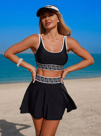 Woman in black athletic outfit with white accents on a beach