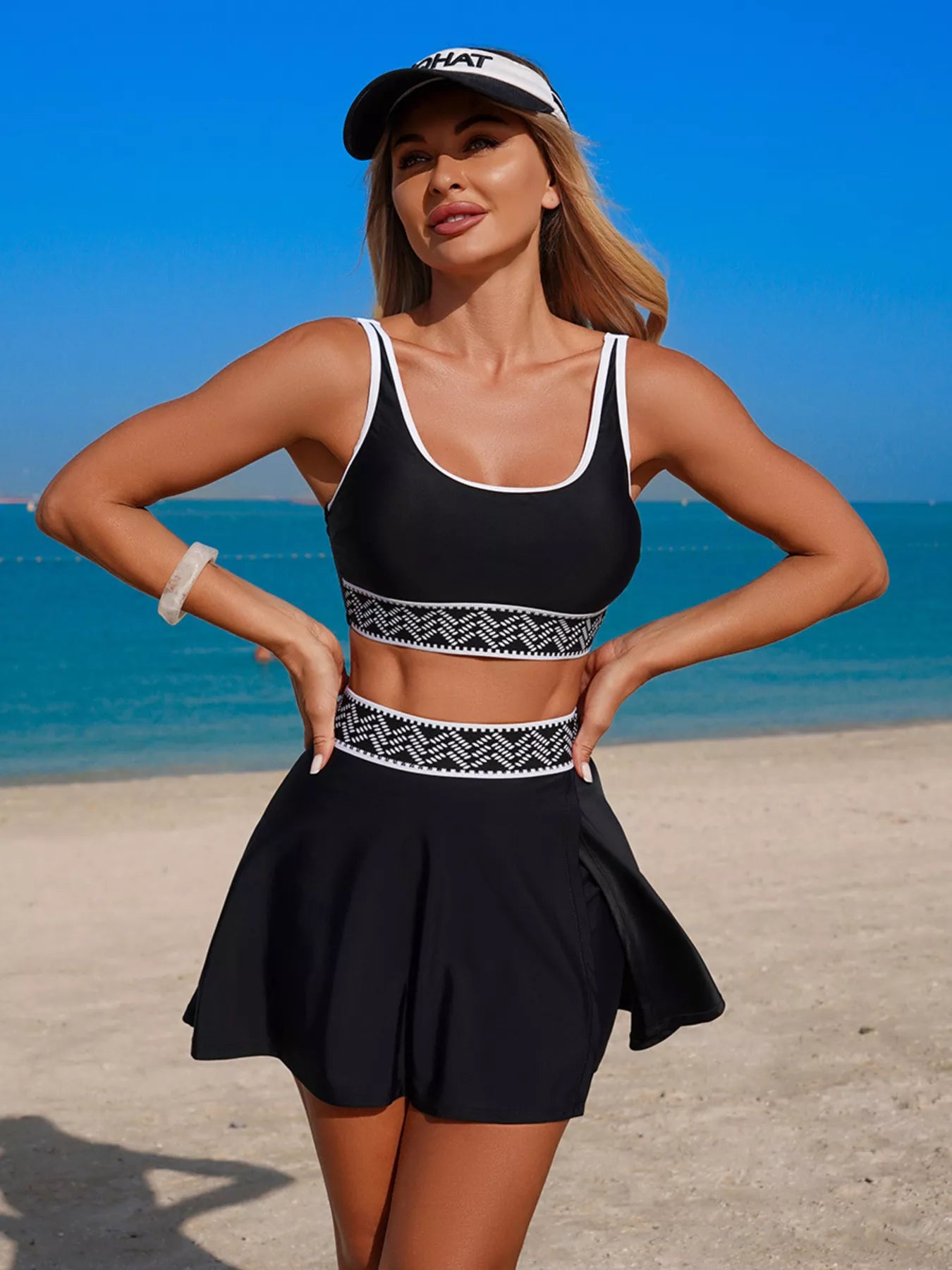 Woman in black athletic outfit with white accents on a beach