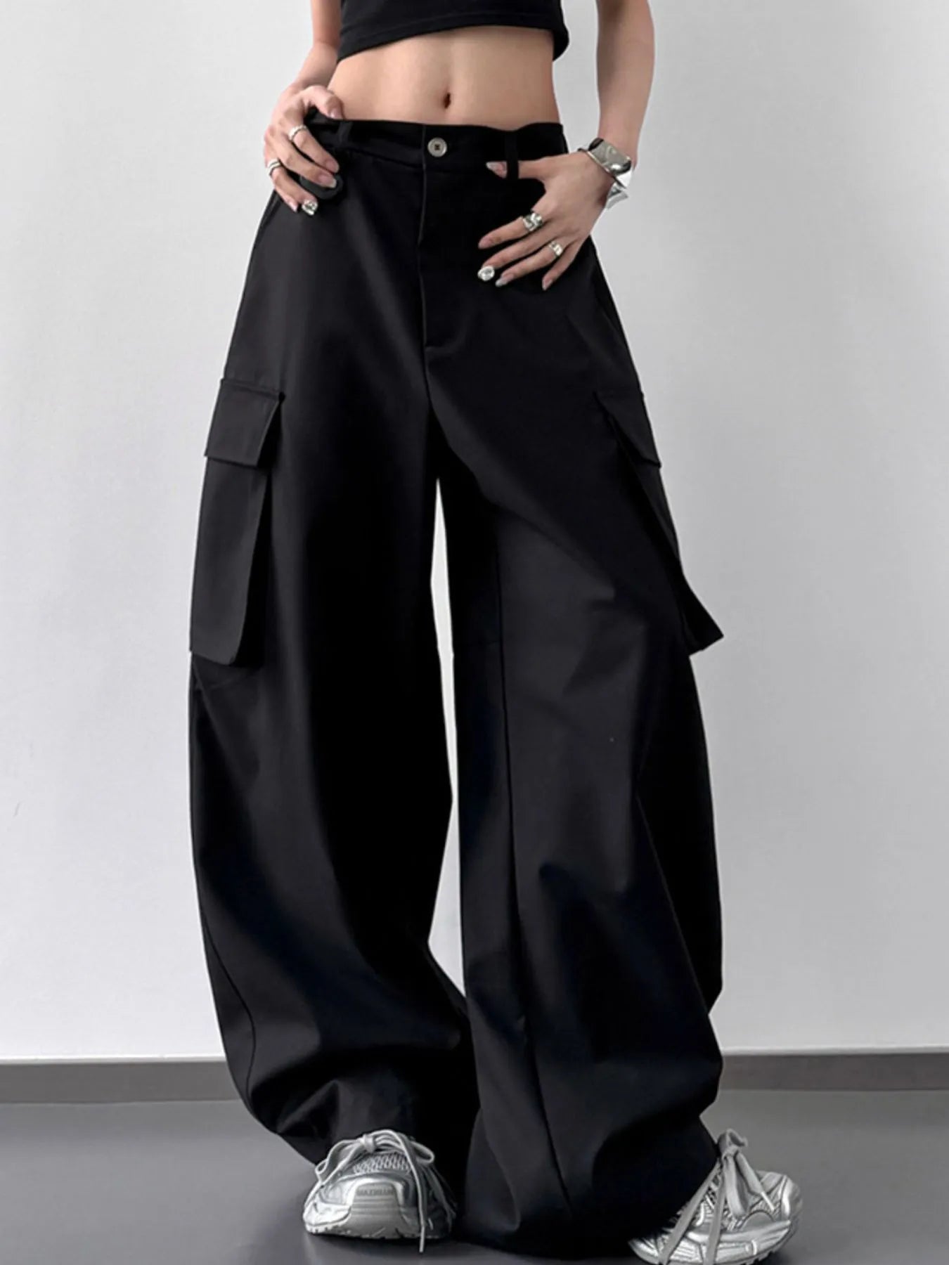 Person wearing black wide-leg cargo pants on a plain background