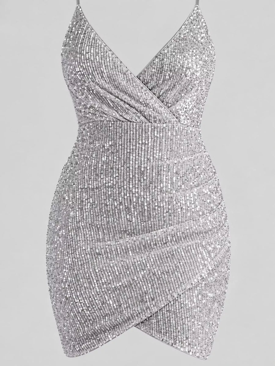 A silver sequined mini dress with a crossover wrap-style bodice and draped skirt, shown against a solid gray background.